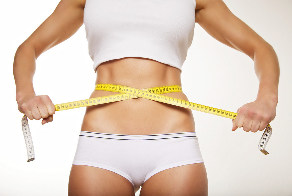 fit woman measuring waist size